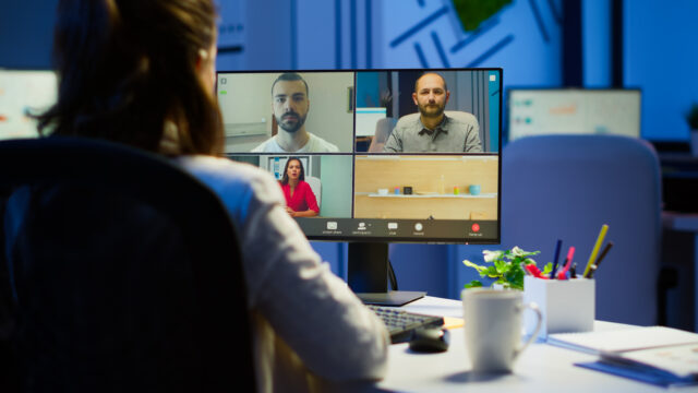 Back view of business woman talking about sale report in video conference