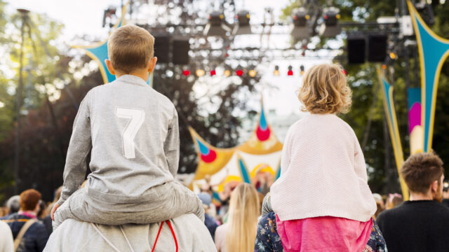 Boy and girl being carried on shoulders during festival