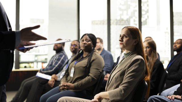 Business summit in conference hall with professional audience seated on chairs