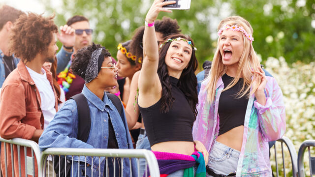 Female Friends Taking Selfie As They Arrive At Entrance To Music Festival