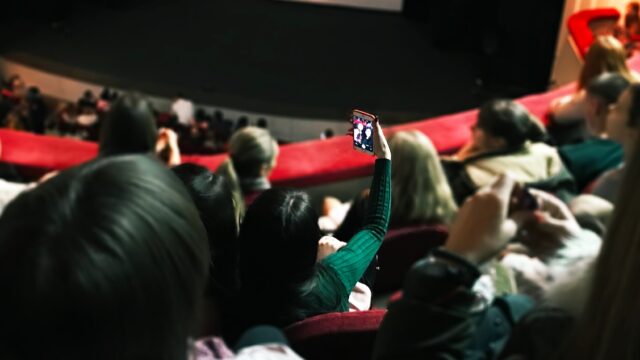 friends-taking-photo-using-mobile-phone-while-wait-2026-03-23-23-49-35-utc