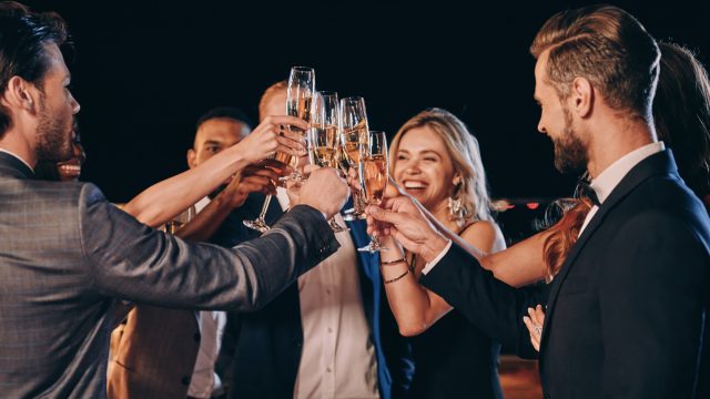 Group of beautiful people in formalwear toasting with champagne