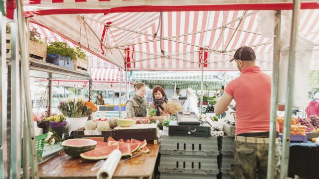 Mature women buying fruits at market stall