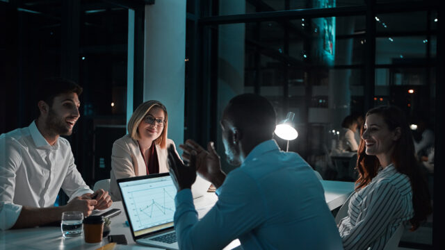 people-happy-laptop-office-night-with-documents-deadline-overtime-as-accountant-employee-partnership-teamwork-financial-reviews-records-screen-with-graph-feedback