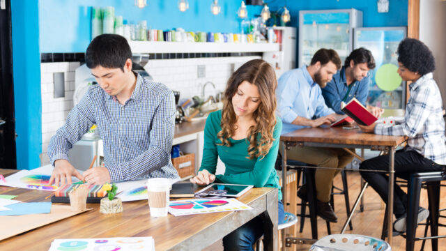 People working office sitting desk modern open coworking space mix race colleagues