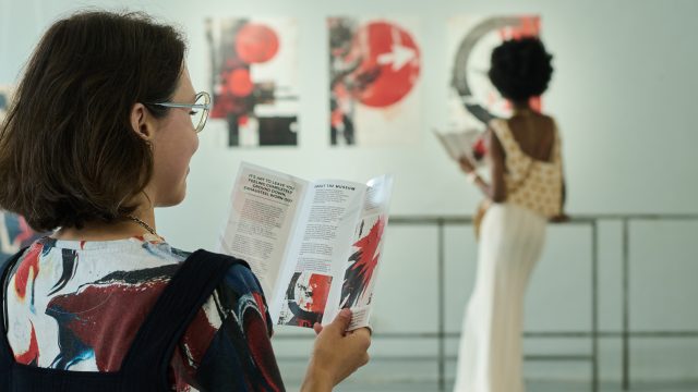 Visitor of modern gallery with brochure