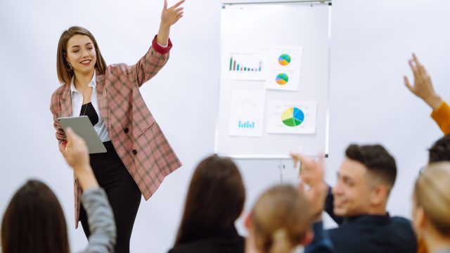 Young woman coach speaker giving flipchart presentation, speaker leading training